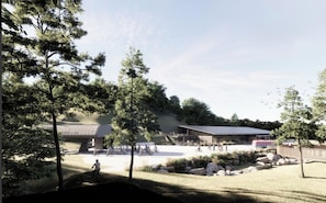 A park with a building, trees, and people.