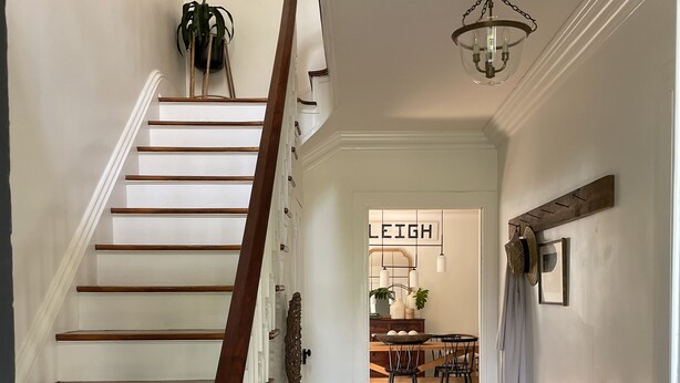 A staircase with wooden steps and a white balustrade, leading to a dining area with a chandelier and a sign that reads "LEIGH". - Bright and Sunny Historic 3-bedroom house in quaint Muncy (Muncy)
