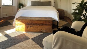 A bedroom with a bed, a ceiling fan, a window with curtains, a bedside lamp, a framed picture on the wall, and a large plant. - Bright and Sunny Historic 3-bedroom house in quaint Muncy (Muncy)