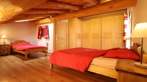 Une pièce en bois avec deux lits en bois, une armoire en bois et un plancher en bois.