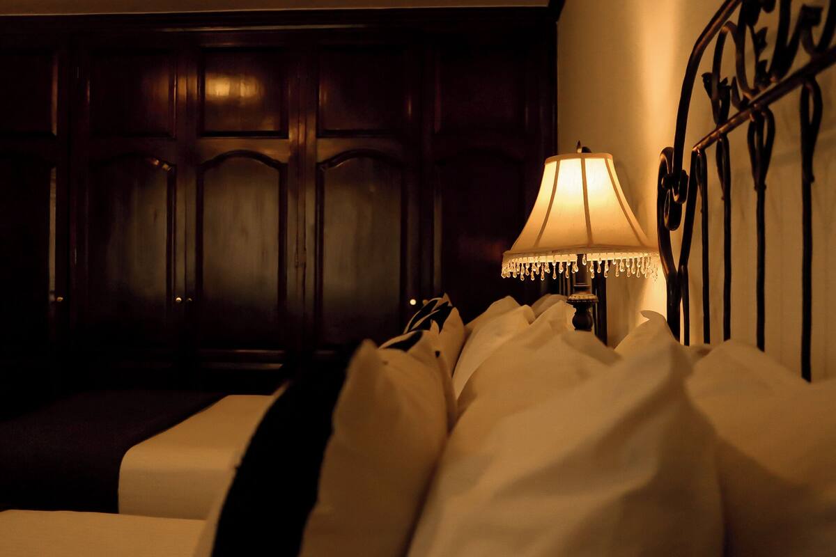 Ein Hotelzimmer mit einem Bett, einer Lampe und einem dunklen Holzschrank.