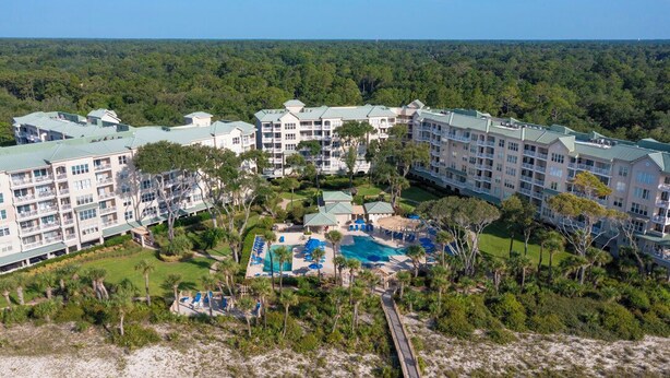 A resort with multiple buildings, a swimming pool, and a beach area. - Serene 5th floor Villa with Two Balconies! (Hilton Head)