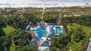 A resort with a large swimming pool, multiple sun loungers, and a beach view. - Serene 5th floor Villa with Two Balconies! (Hilton Head)
