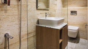 Une salle de bain moderne avec une douche à parois de verre, un meuble-lavabo en bois et des toilettes.