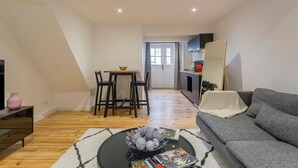 Un salon moderne comprenant un canapé, une table basse et un coin repas avec des chaises et une table.
