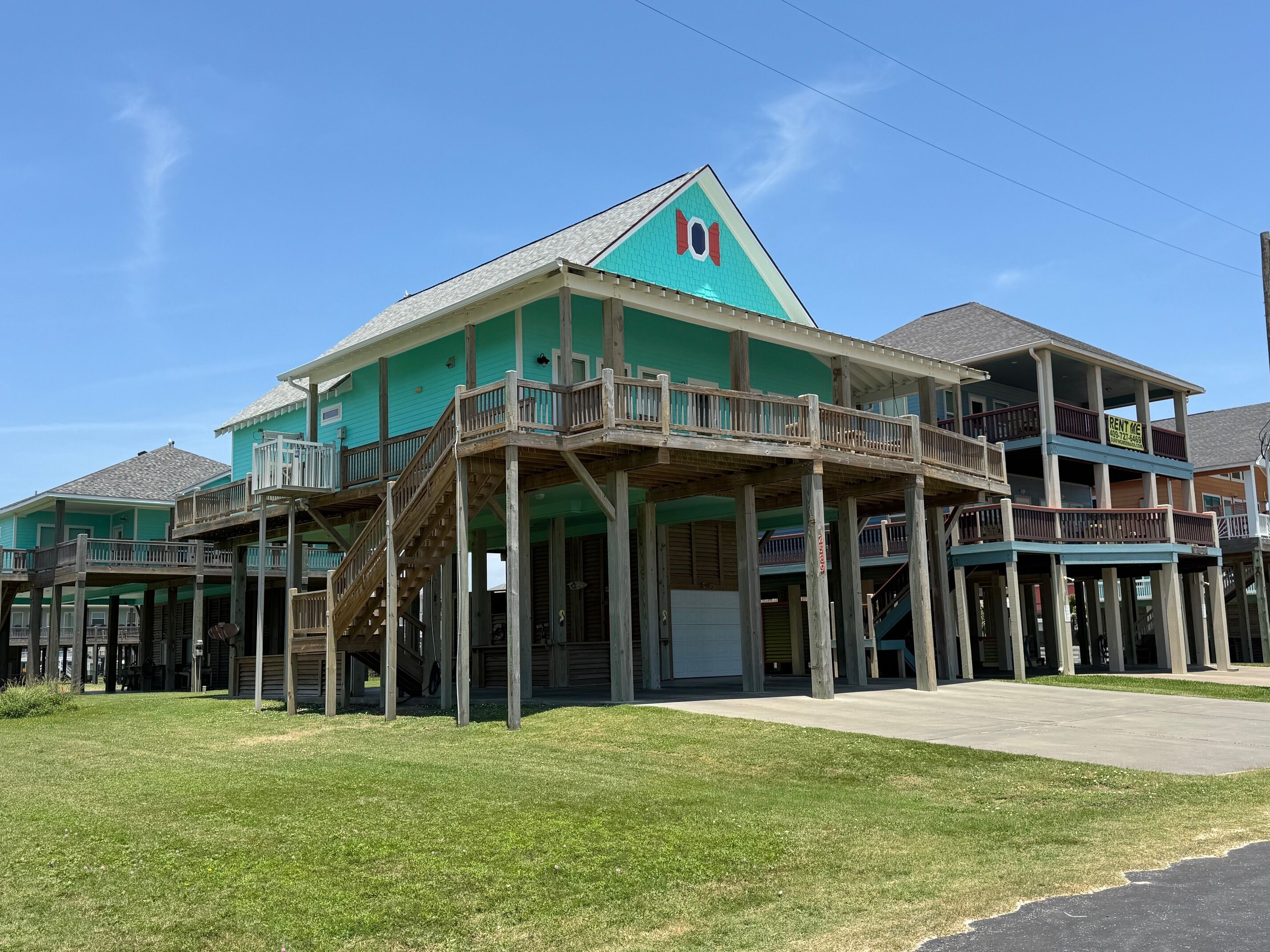 A two-story building with a green facade and wooden balconies.