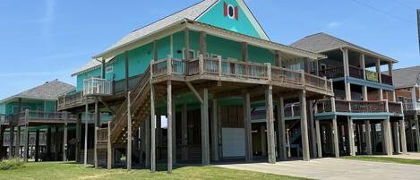 A two-story building with a green facade and wooden balconies.