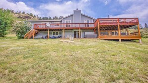A two-story house with a covered deck and a staircase leading to the upper level. - fishing, hot tub and room to roam! (Shawnee)