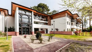 A modern multi-story building with a central courtyard, large windows, and a mix of brick and wood exterior.