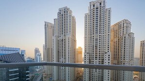 Ein hoch aufragender Wohnkomplex mit mehreren Wohntürmen, einem zentralen Innenhof und einer umliegenden Stadtlandschaft mit Straßen und weiteren Gebäuden.