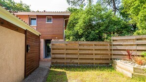 Il s’agit d’une propriété résidentielle dotée d’une clôture en bois, d’un chemin pavé et d’un espace jardin.