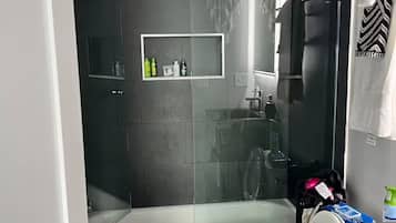 Chuveiro, toalhas de banho, sabonete, shampoo