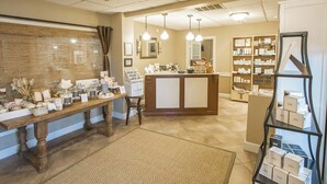 A reception area with a reception desk, a waiting area with a bench, and a display of products.