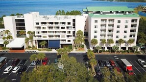 A multi-story hotel with a central courtyard, parking lot, and a view of the ocean. - Oversized 2BR Condo Near the Beach (Destin)