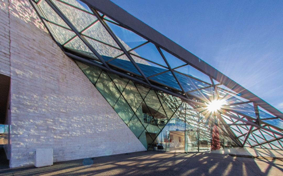 A modern building with a glass facade and a metal framework.