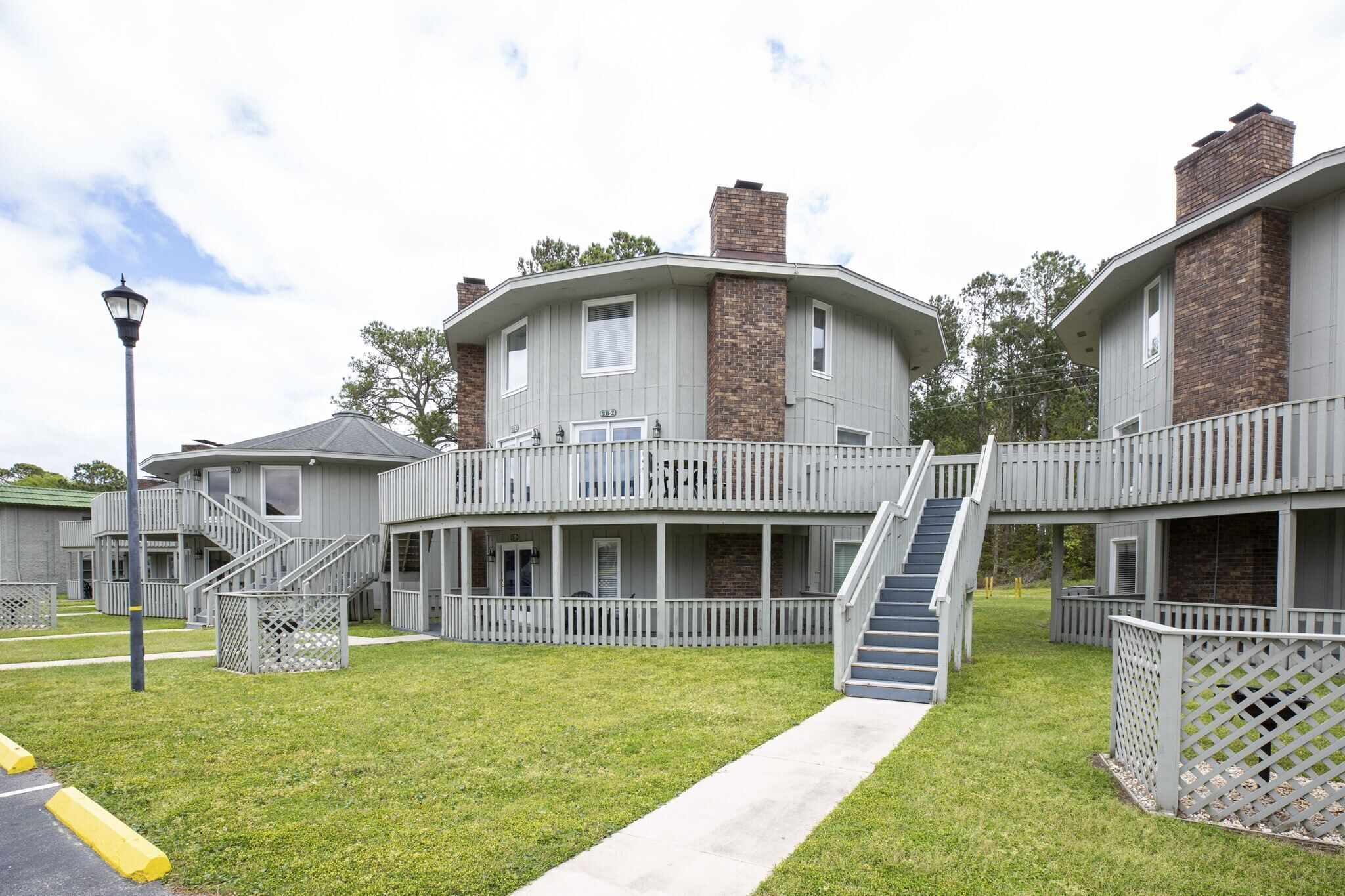 A two-story building with a central staircase, a covered porch, and a brick chimney.