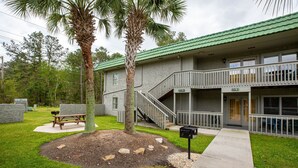 A two-story building with a green roof, a balcony, and a staircase leading to the upper floor. - Spacious 3BR Villa w/ Pool near Surfside Beach (Surfside Beach)