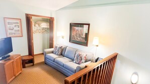 A living room with a sofa, TV, and a wooden staircase. - Nature Escape w/ Resort Amenities, Sleeps 4 (Lake Lure)