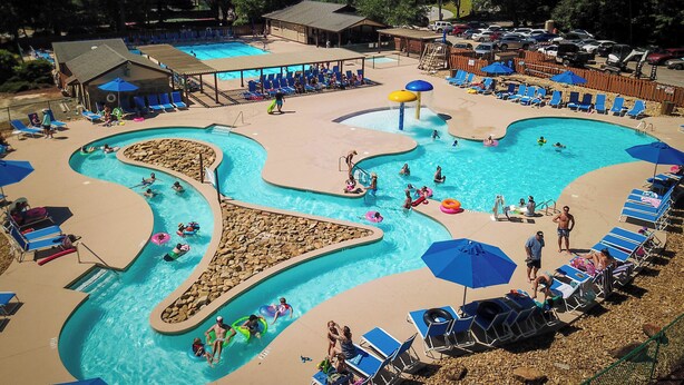 A large outdoor swimming pool with multiple lanes and a separate area for water slides.