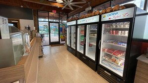 A clean, well-lit store with a variety of refrigerated display cases and a counter with packaged goods. - 1BR Villa near Disney & Universal (Kissimmee)