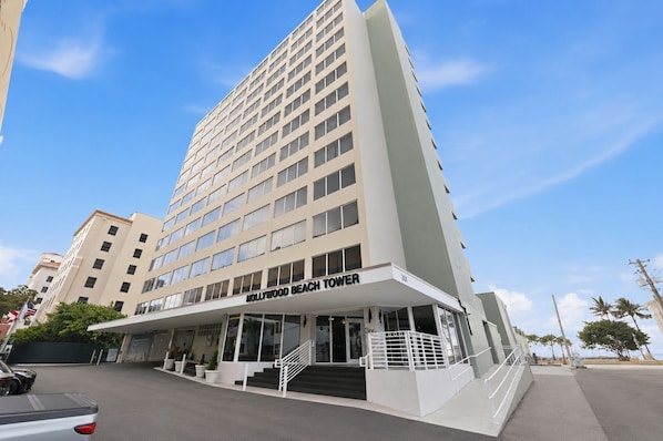 A multi-story hotel with a prominent entrance and a staircase leading to the lobby.