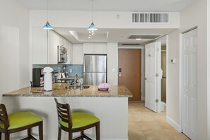 A modern kitchen with a central island, stainless steel appliances, and a bright, open layout. - Oceanfront Studio w/ Pool in Hollywood Beach (Hollywood)