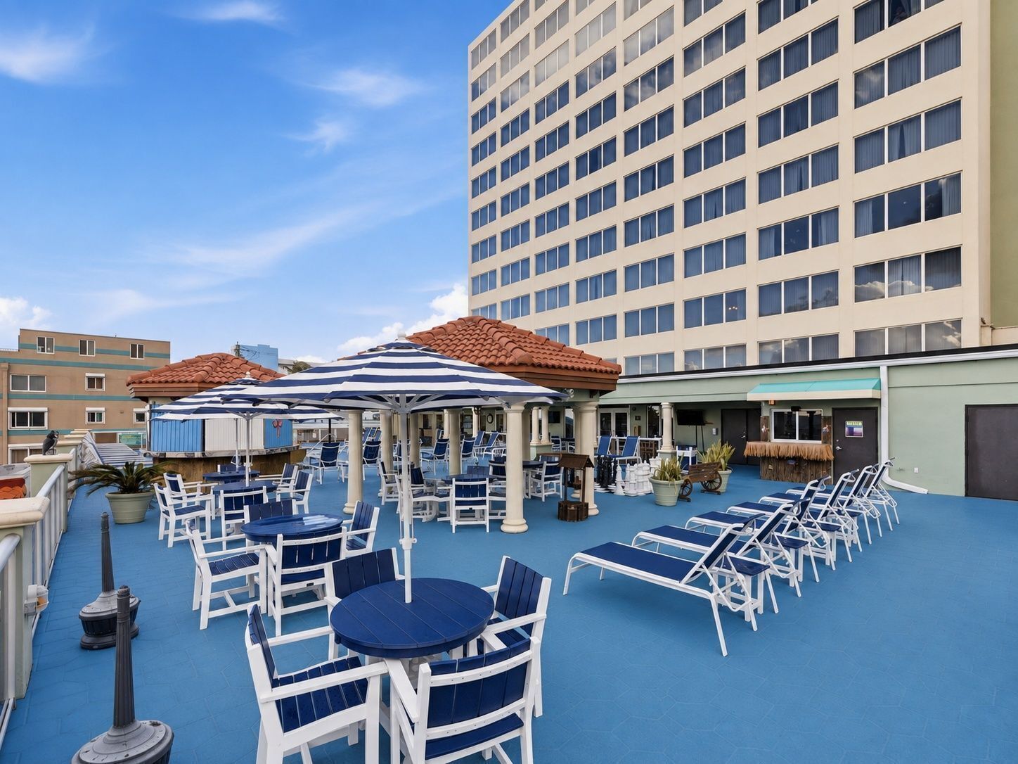 A rooftop terrace with outdoor seating and a view of a tall building.