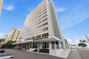 A multi-story hotel with a prominent entrance and a staircase leading to the lobby.