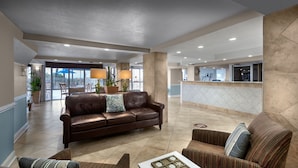 A spacious lobby with a leather sofa, striped armchairs, and a coffee table.