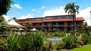 A hotel with multiple floors, outdoor seating, and lush greenery. - 1BR Oceanview Condo w/ Pool & Balcony in Kihei (Kihei)