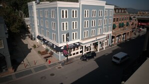 A multi-story hotel with a blue facade, a ground floor restaurant, and a visible parking area.