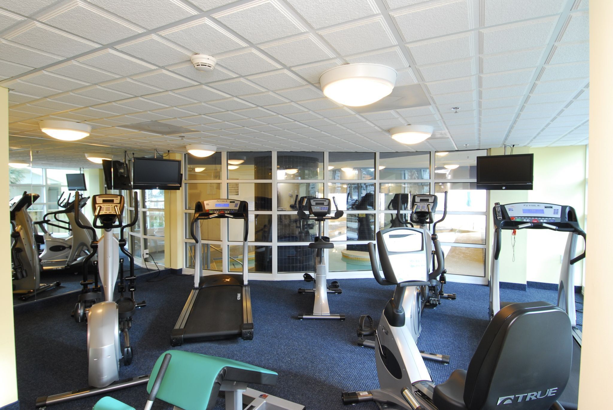 A gym with treadmills, elliptical machines, and exercise bikes.