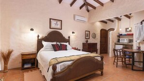 A bedroom with a wooden bed, bedside tables, a desk, and a chair. - A Tropical Paradise - Painted Pony Ranch B&B just 25 minutes to Pacific Beaches (Portegolpe)