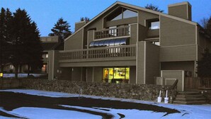 A two-story building with a balcony and a ground-level entrance. - 1-Bedroom Condo near Lake Wallenpaupack (Hawley)