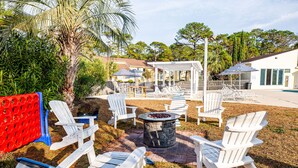An outdoor seating area with Adirondack chairs and a fire pit.