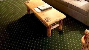 Un espacio habitable pequeño con kitchenette, un sofá, una mesa de centro y una lámpara.