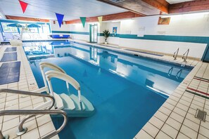 Une piscine intérieure avec des couloirs clairement délimités, une chaise de maître-nageur et un poste de surveillance pour le maître-nageur.