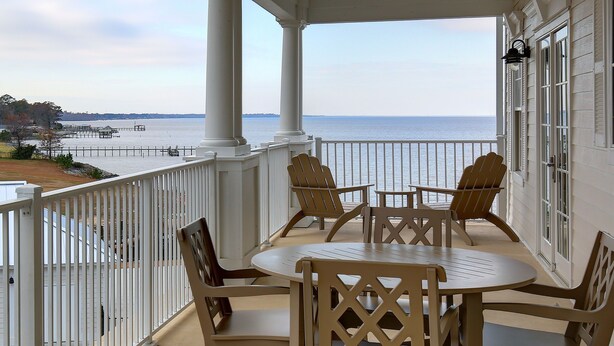 A covered outdoor seating area with a view of the water. - Waterfront 2BR Condo with Stunning Sound Views (Roper)