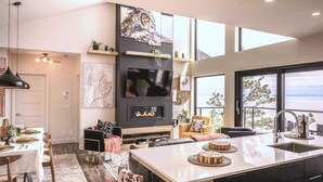 Una cocina moderna con una isla grande, electrodomésticos integrados y vistas al océano.