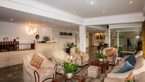 A hotel lobby with a reception desk, seating area, and a glass wall with a bicycle. - WOT Pateira Soul (Agueda)