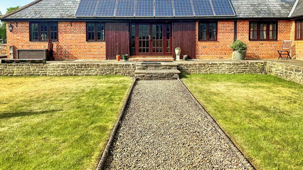 A brick building with a sloped roof and solar panels.