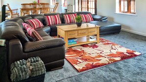 A living room with a sectional sofa, wooden coffee table, and a patterned rug.