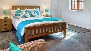 A bedroom with a wooden bed, two bedside tables, a window, and a door.