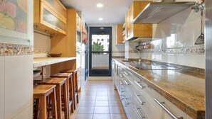 Una cocina con armarios de madera, una encimera y vistas a través de la puerta.