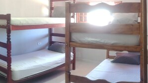 Uma cama beliche com estrutura de madeira e roupa de cama branca.