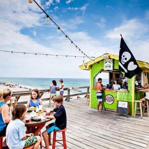 A beachside restaurant with outdoor seating overlooking the ocean.