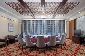 A conference room with a round table, chairs, and a television. - Qingdao West Coast City Terrace Detai Hotel (Qingdao)