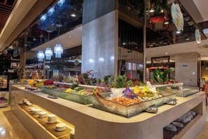 A buffet area with various food items and a counter. - Qingdao West Coast City Terrace Detai Hotel (Qingdao)