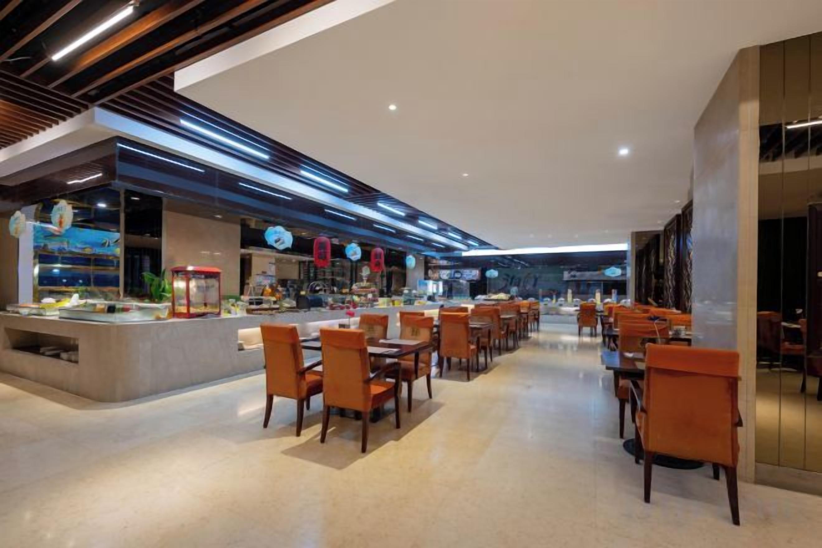 A modern restaurant with a long counter and multiple tables.