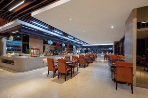 Un restaurant moderne avec un long comptoir et de nombreuses tables.